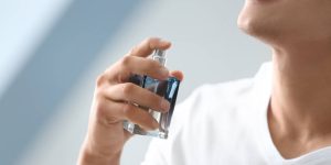 Homem branco de camiseta branca se perfumando