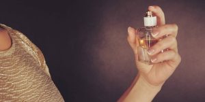 Imagem do braço de um mulher passando perfume em si mesma