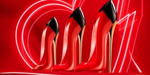 Três frascos do perfume Very Good Girl lado a lado sobre um fundo vermelho