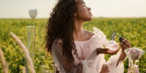 Mulher negra se perfumando em um campo aberto em um dia quente