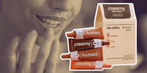 Hidratantes labiais da Collab Creamy e The Coffee em destaque; ao fundo, close no rosto de uma mulher tocando os próprios lábios