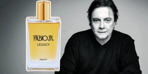 Um frasco do perfume Legacy, e ao fundo uma foto do cantor Fábio Jr