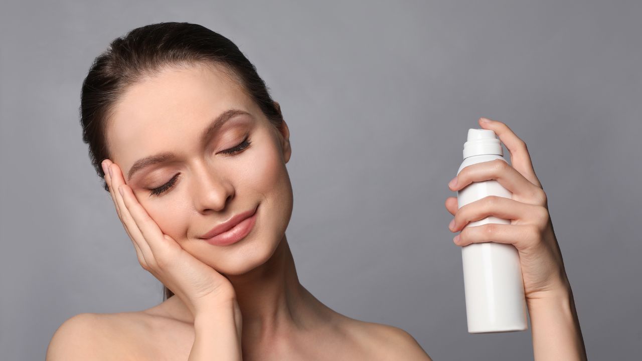 mulher aplicando água termal no rosto